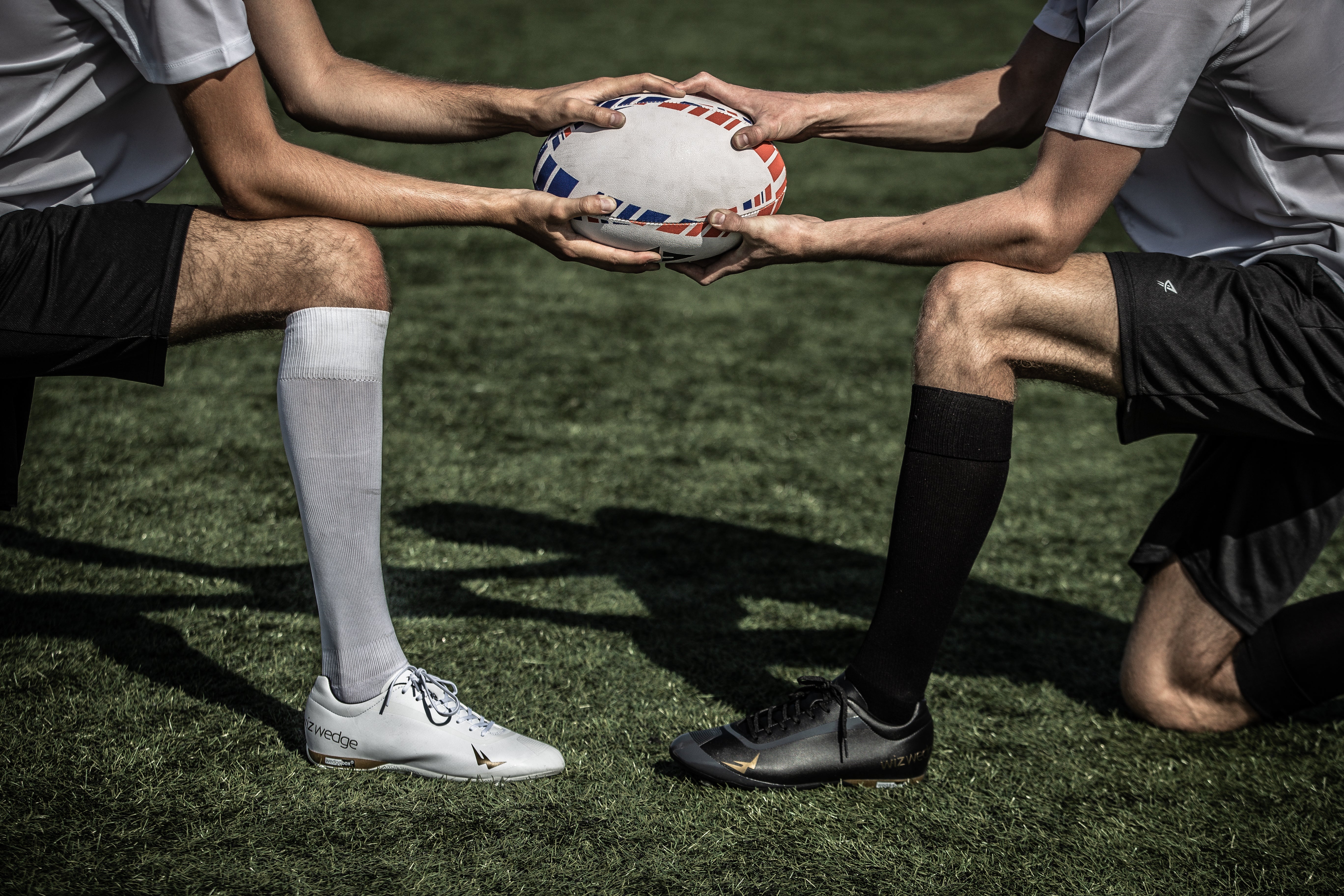 Joueur de football homme faisant des jongles avec des crampons de football rugby Wizwedge noires