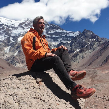 Ara Khatchadourian assis sur un rocher devant les montagnes du Népal avec les chaussures de trail marche nordique Wizwedge Stargon