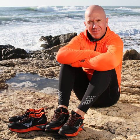 Benoit Z, recordman de France du marathon, assis avec des chaussures de running homme Wizwedge Helium BZ oranges